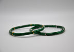 Deux bracelets en jade vert avec accents dorés et argentés sur fond blanc, bijoux élégants.