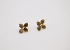 Boucles d’oreilles dorées fleurs quatre pétales pierres naturelles sur fond blanc