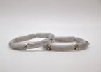 Bracelets jonc en jade gris avec accents dorés et argentés sur fond blanc, bijoux élégants