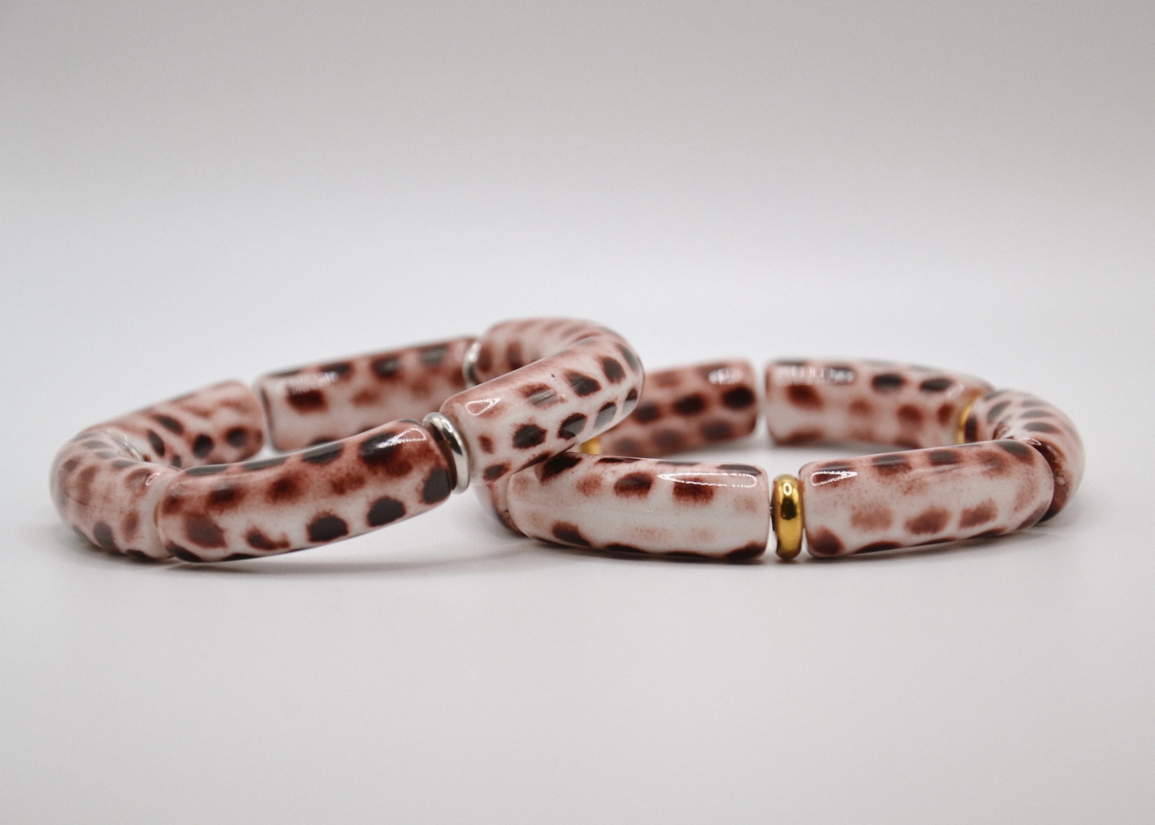 Bracelets céramique tachetés marron blanc avec accents dorés sur fond blanc, bijou tendance