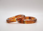 Deux bracelets en résine marron effet marbré sur fond blanc, bijoux tendance.