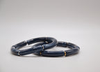 Deux bracelets bleu marine en résine à segments, fond blanc, style minimaliste élégant