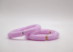 Bracelets modernes en résine violette avec détails dorés et argentés sur fond blanc