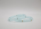 Bracelets en jade bleu pâle avec accents dorés et argentés sur fond blanc minimaliste