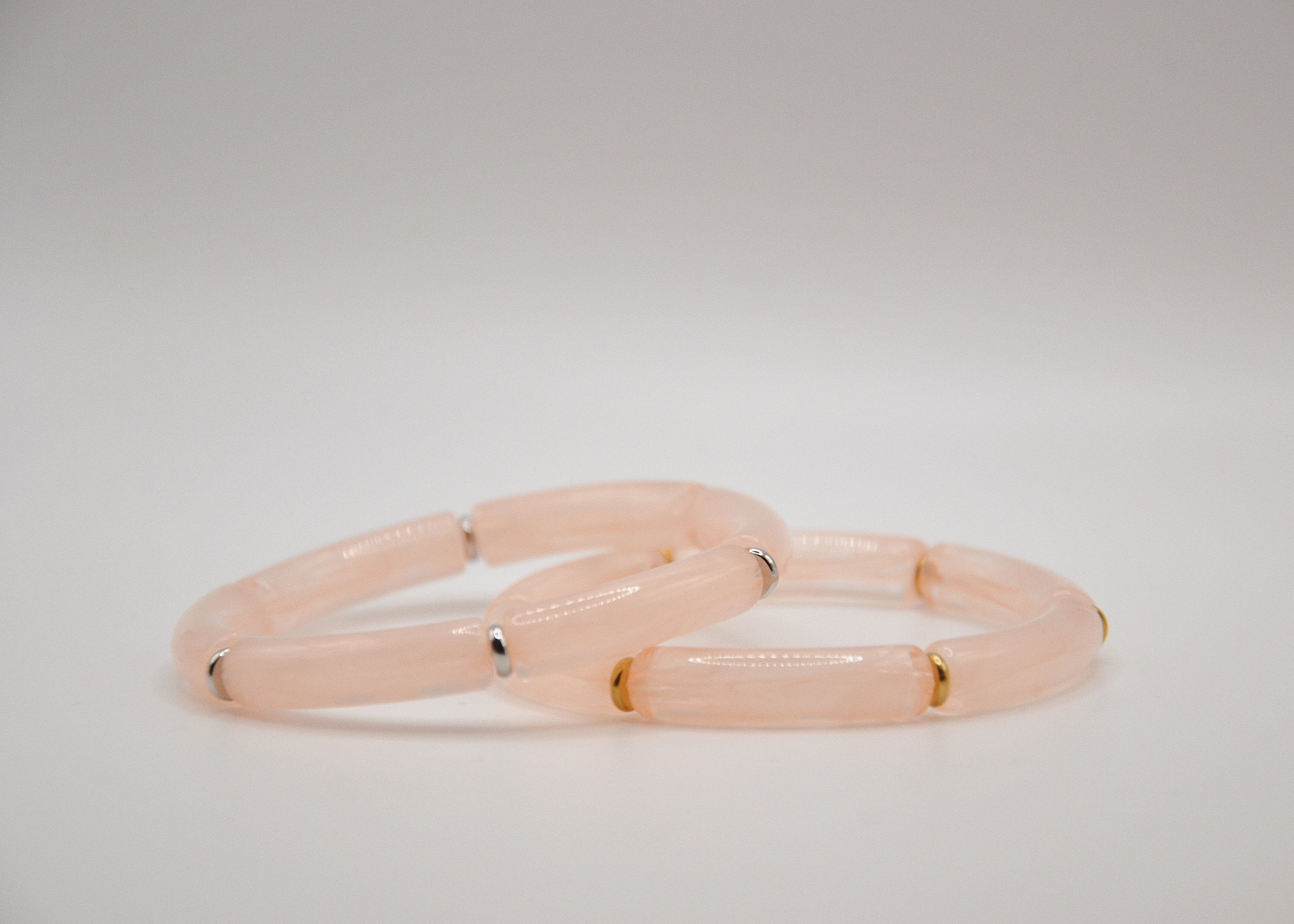 Bracelets pierres naturelles rose quartz cylindriques, connecteurs dorés et argentés, fond blanc
