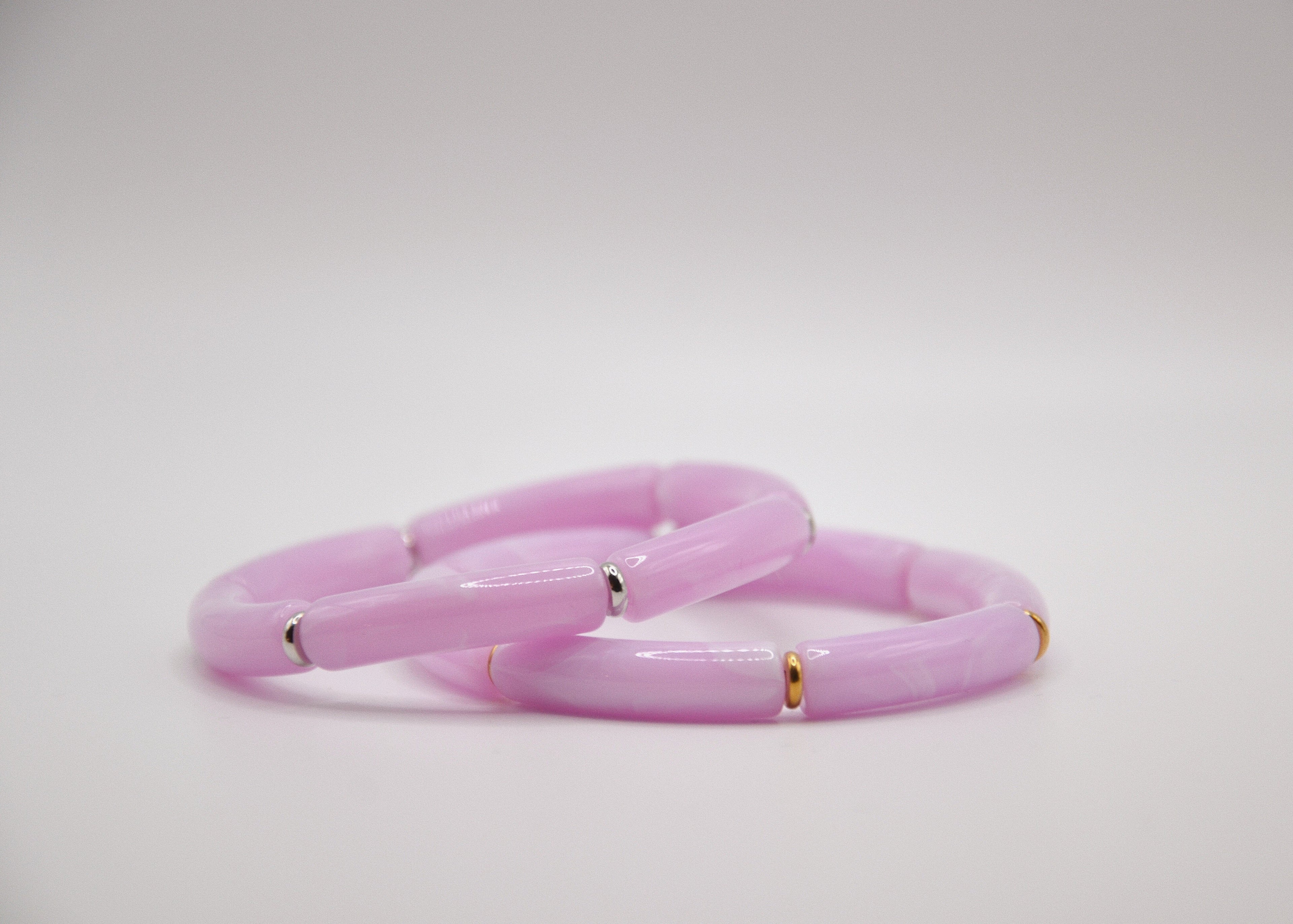 Bracelet femme rose pastel, perles tubulaires, détails dorés et argentés, fond blanc épuré
