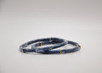 Bracelets bleus effet marbré avec anneaux dorés et argentés sur fond blanc, bijou moderne.