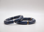 Bracelets en résine bleu foncé avec accents dorés, sur fond blanc, bijou tendance.